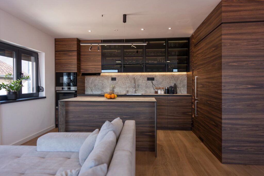 Modern Open-Plan Kitchen With Wood Cabinets, Island and Living Room Sofa in Natural Light
